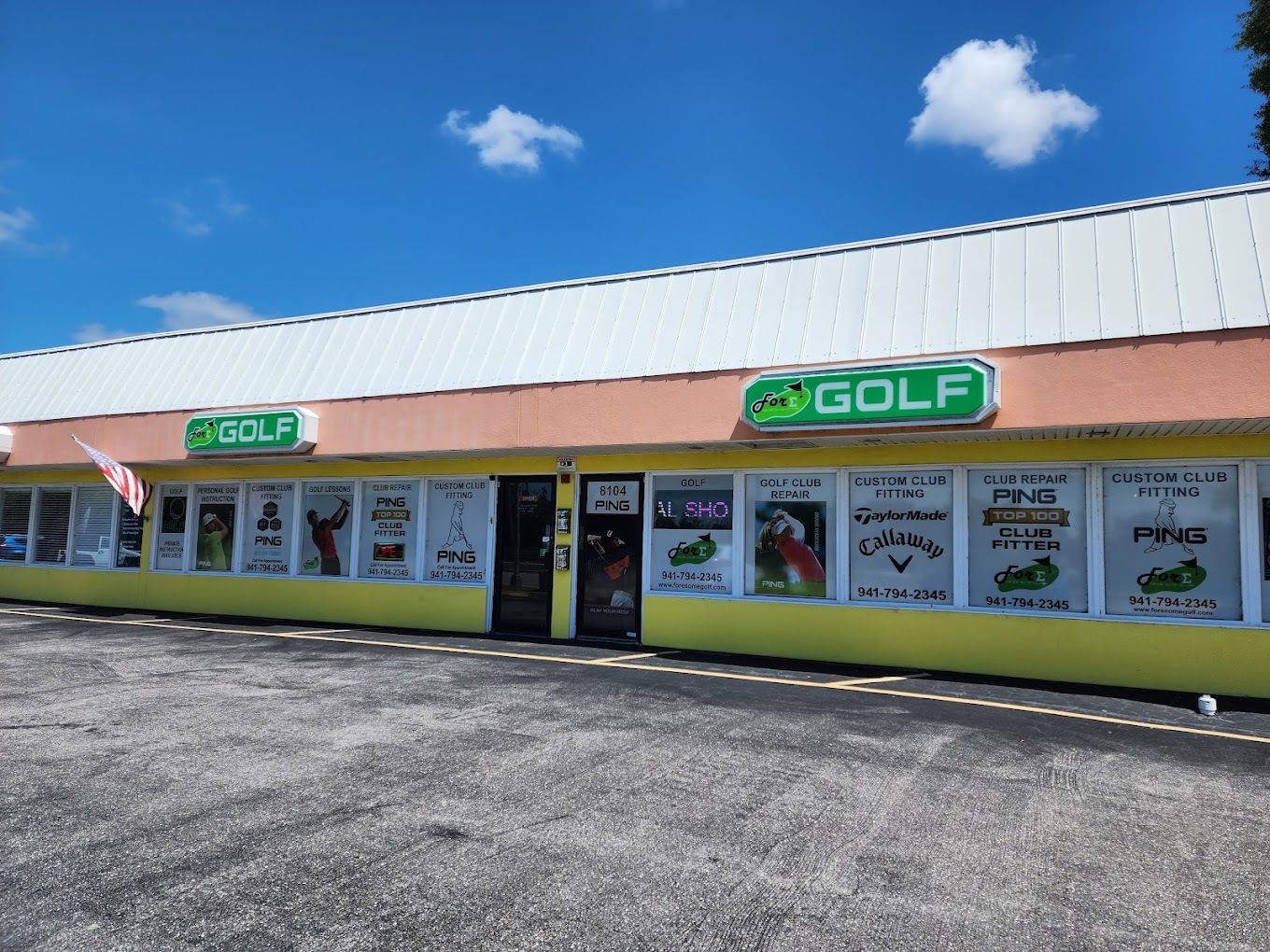 The outside of Fore Some Golf on a sunny day. It is a long and narrow shop with advertisements on the windows.