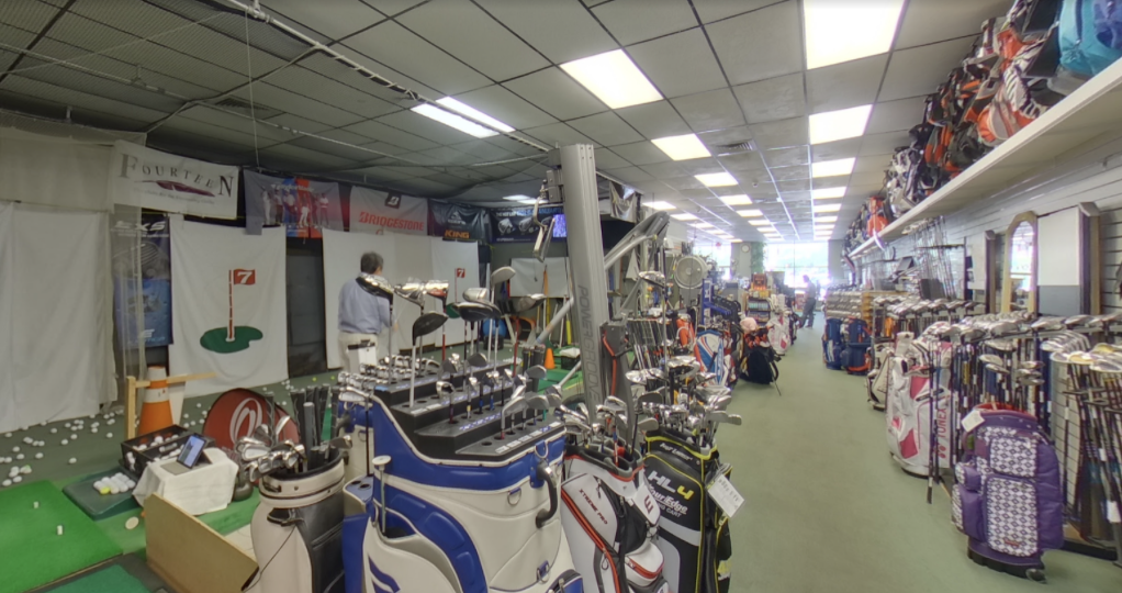 The interior of Annandale Golf features a stacked inventory of golf clubs, bags, and a few hitting bays.