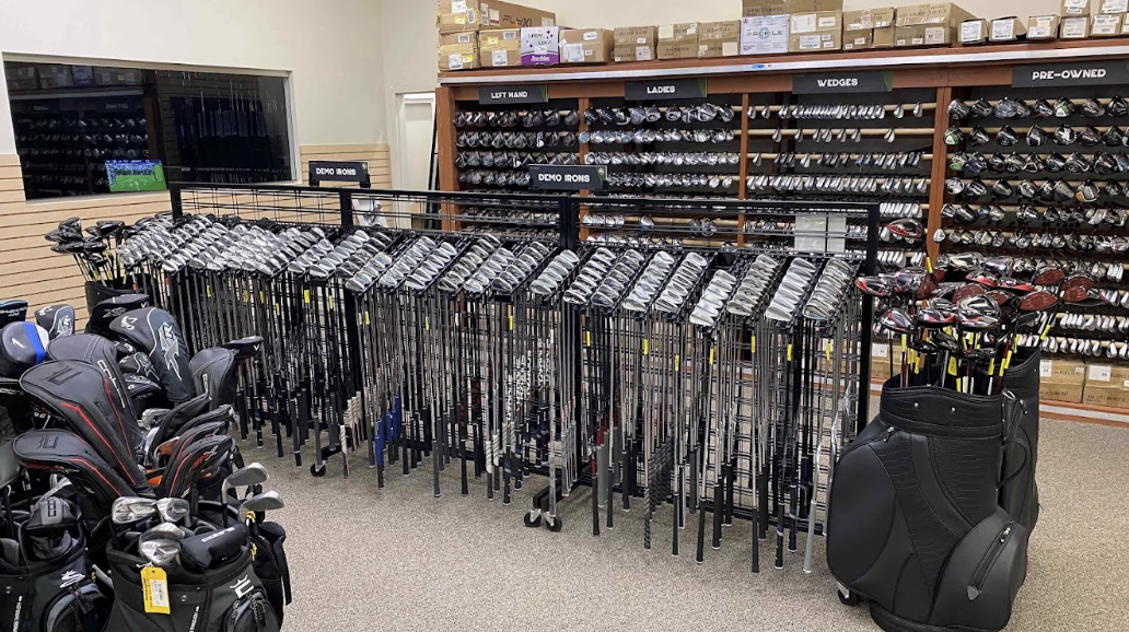 The interior of Edwin Watts Golf featuring a ton of golf clubs including a used section.