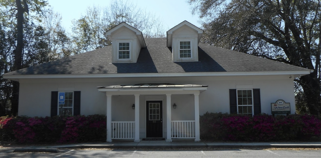 The outside of Usher Golf which looks like a small one-story white town house on a late summer day.