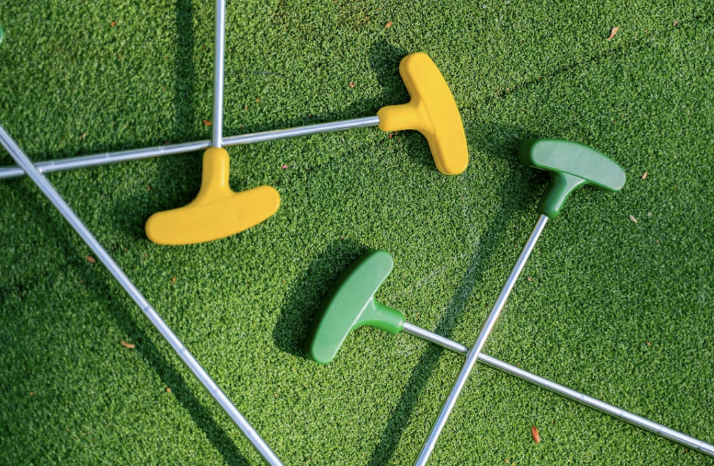 golf putters scattered on the green