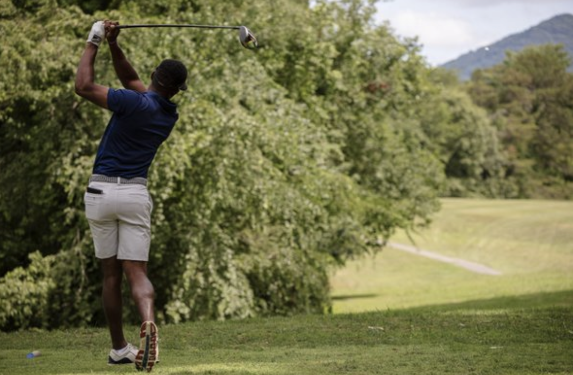 man following through on a golf swing